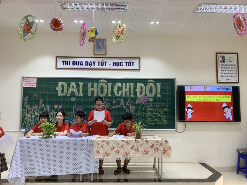 A group of children sitting at a table in front of a chalkboard

Description automatically generated with medium confidence