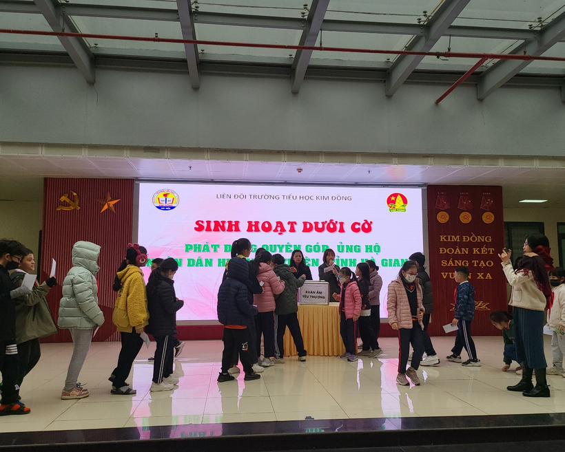 A group of people standing in front of a sign

Description automatically generated with medium confidence