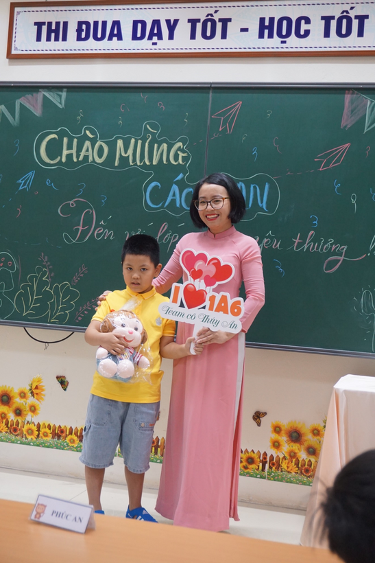 A person and a child standing in front of a sign
Description automatically generated with low confidence