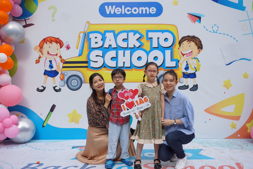 A group of people posing for a photo in front of a sign
Description automatically generated with medium confidence