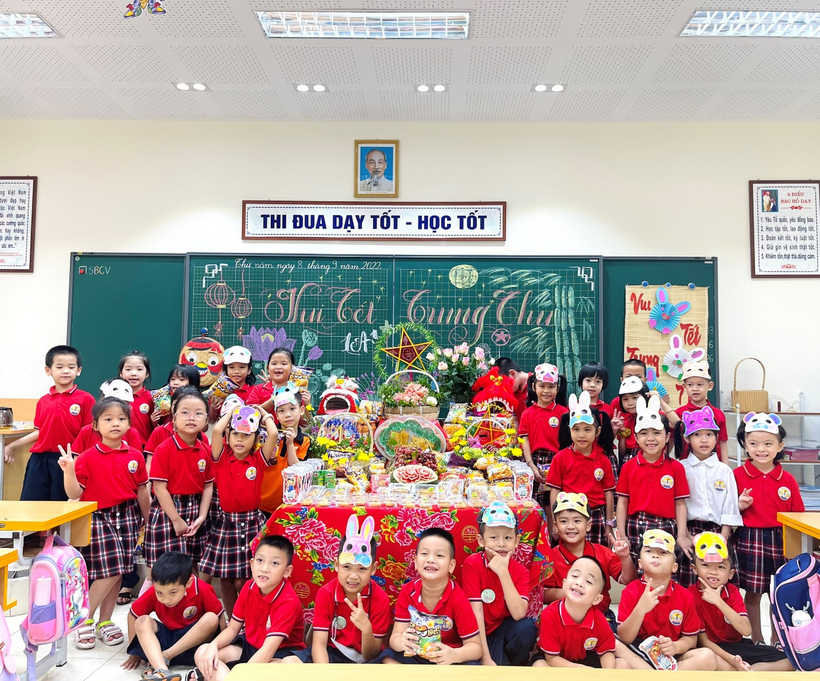 A group of children in red and white uniforms in front of a chalkboard
Description automatically generated with low confidence