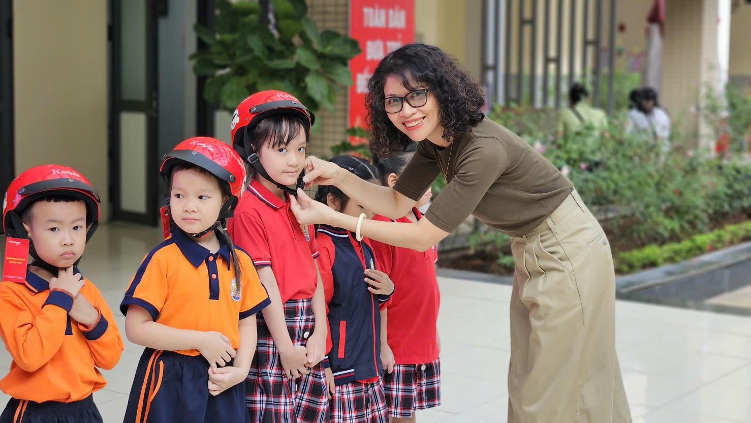 A person helping a group of children with helmets

Description automatically generated