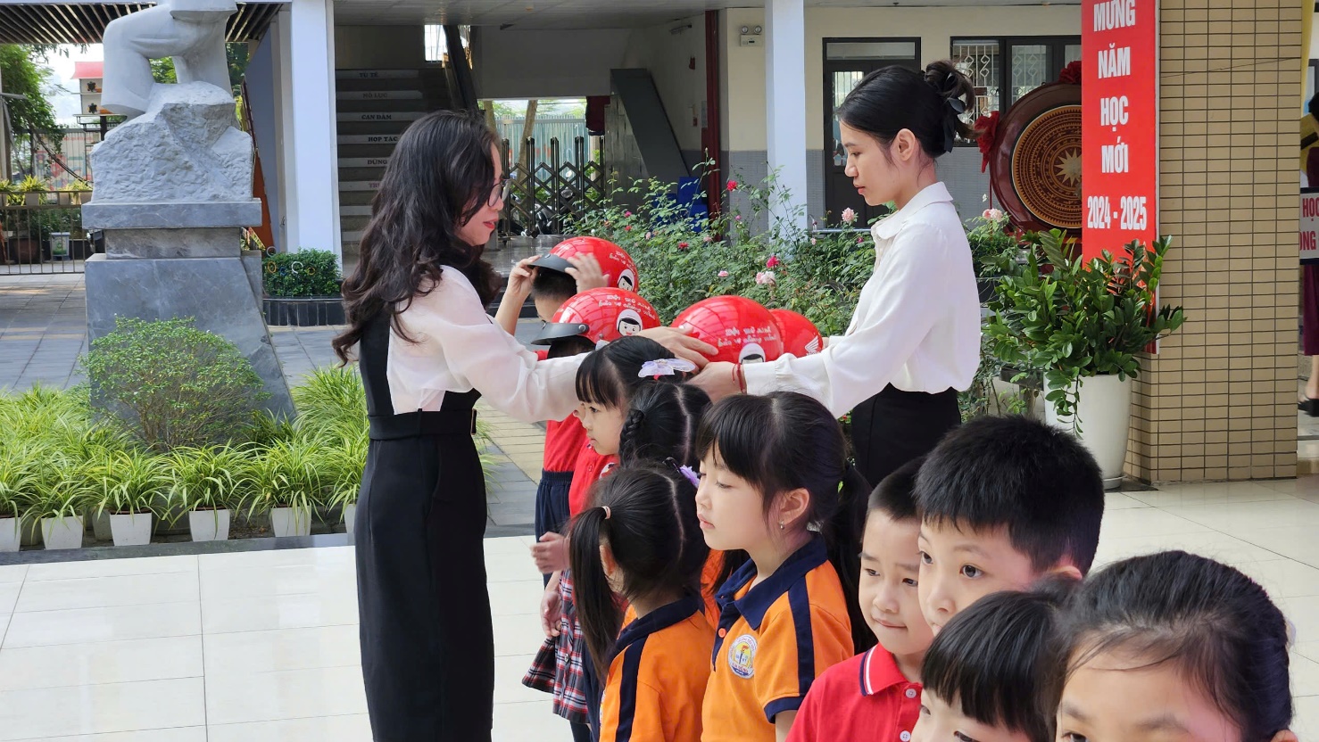 A person and children in front of a building

Description automatically generated