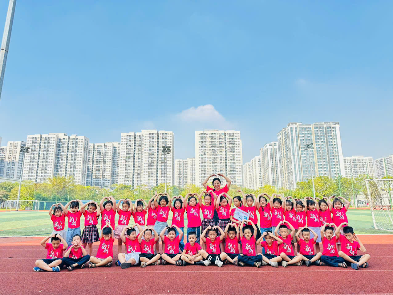 A group of children in red shirts posing for a photo
Description automatically generated