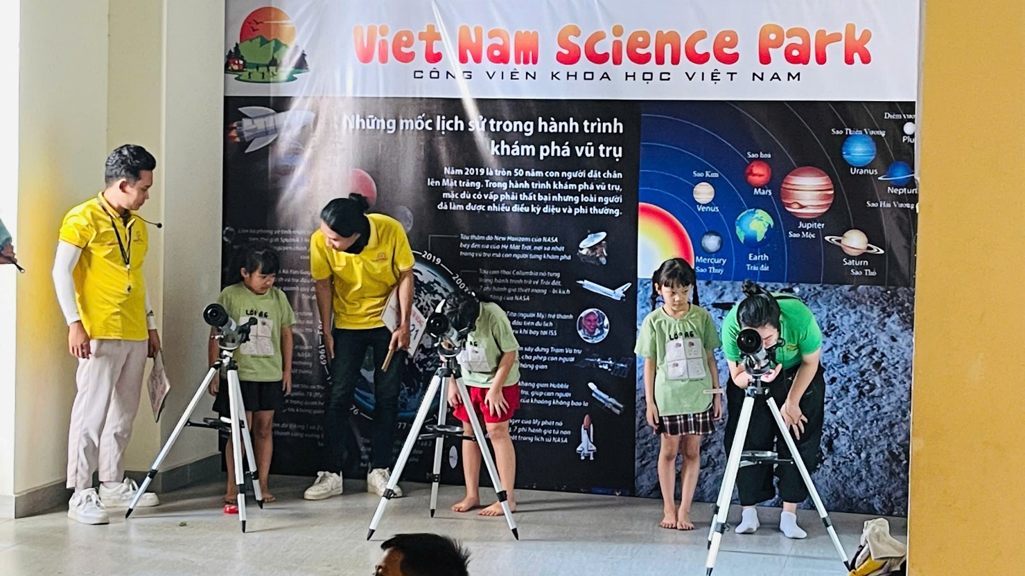 A group of kids standing in front of a banner
Description automatically generated