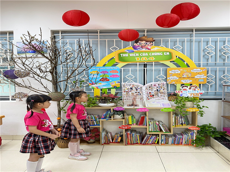Two girls standing in front of a displayDescription automatically generated