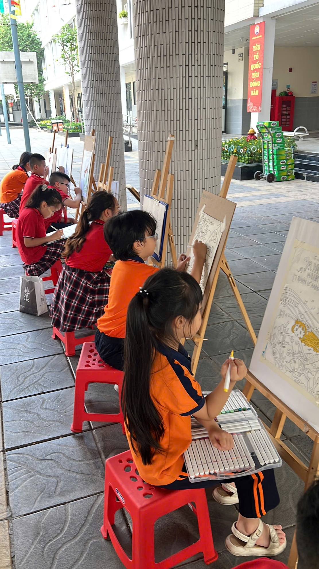A group of children painting on a canvasDescription automatically generated