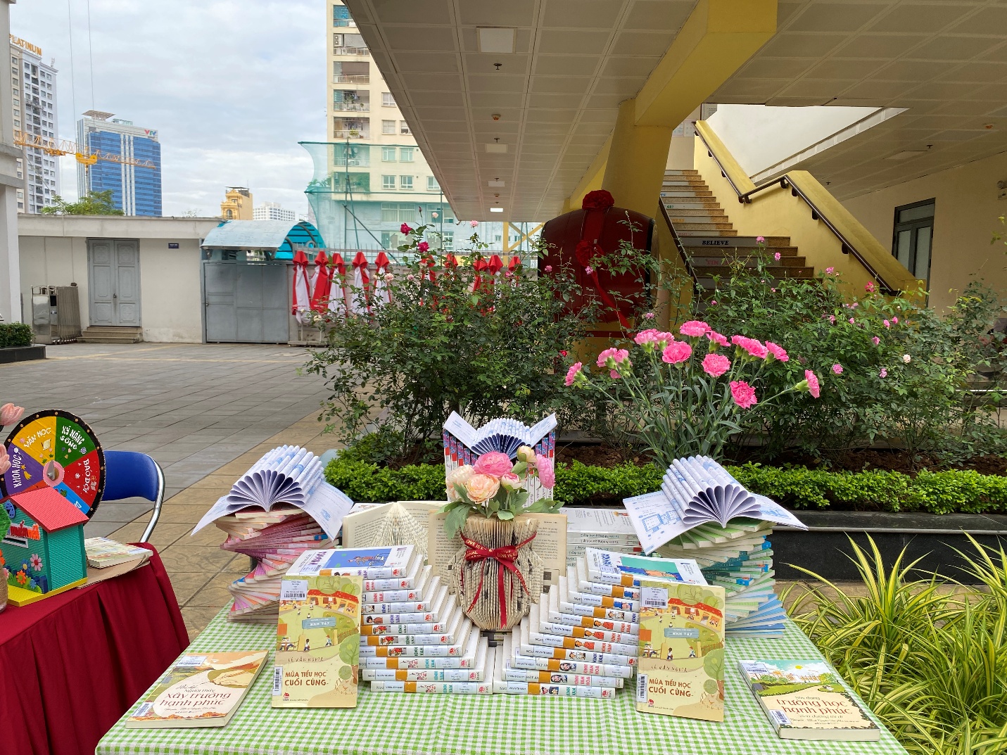 A table with books and flowers on it
Description automatically generated