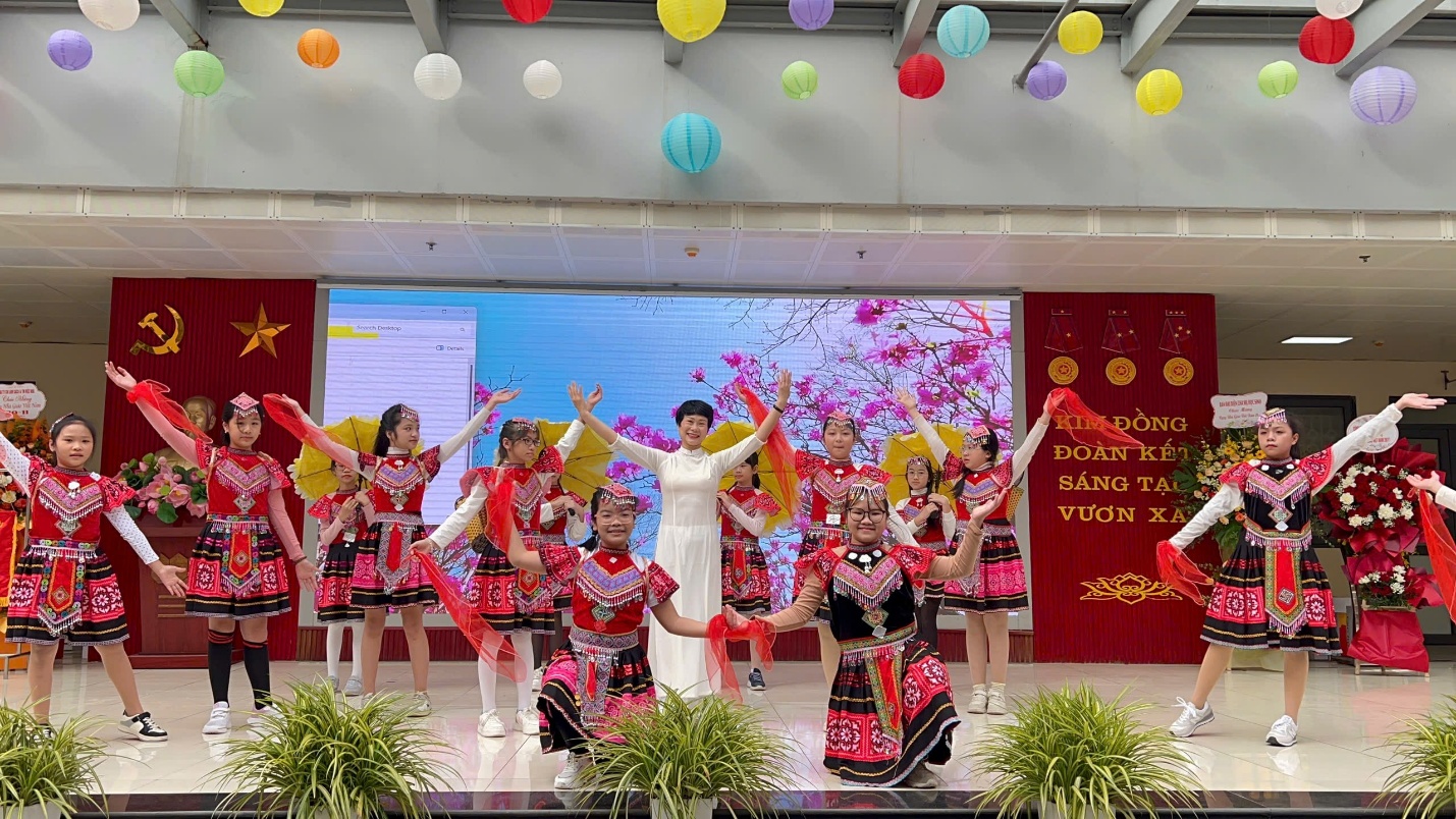 A group of women in traditional clothing on a stage
Description automatically generated
