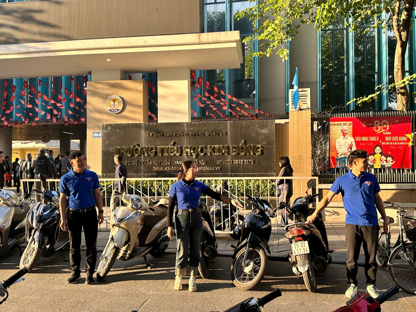 A group of people standing next to motorcycles
Description automatically generated