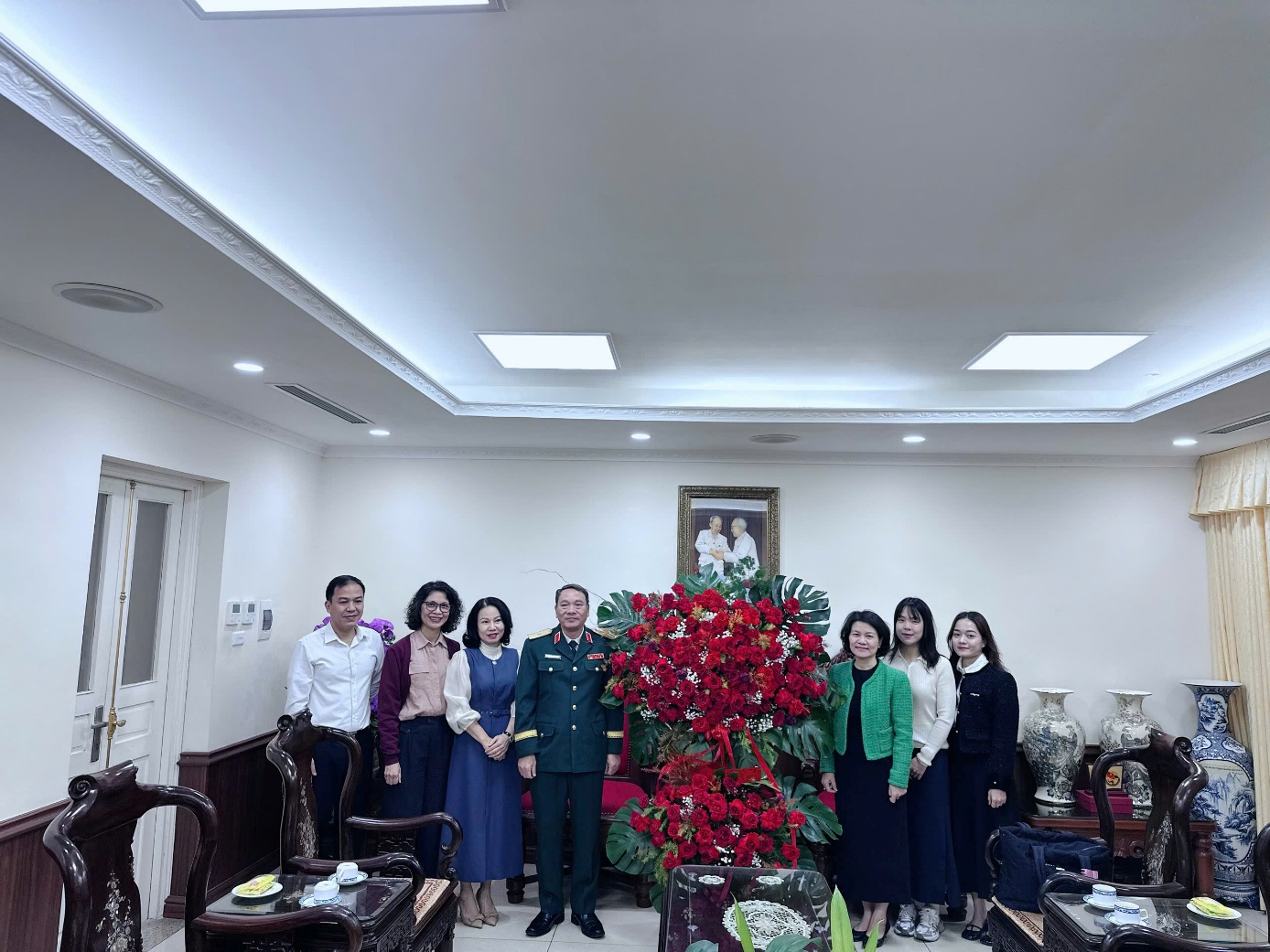 A group of people standing in a room

Description automatically generated