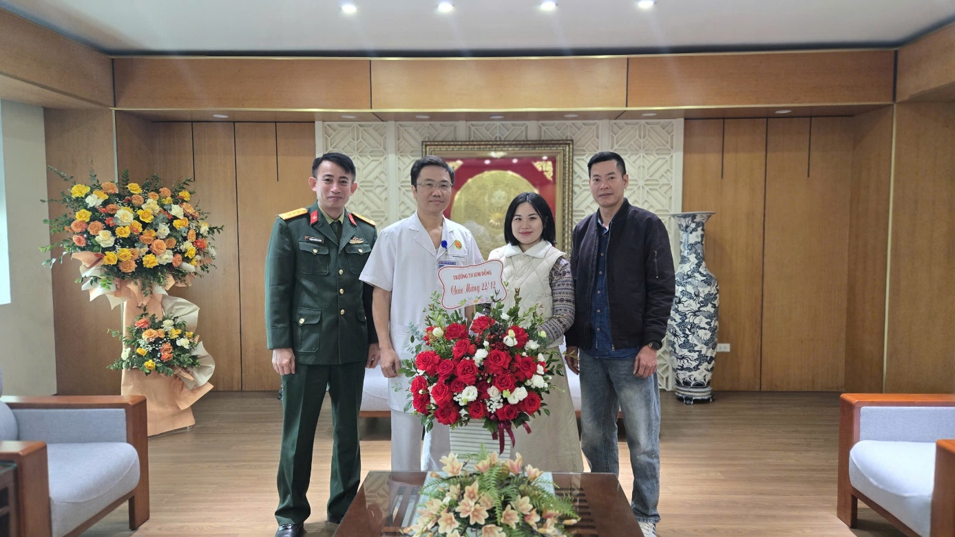 A group of people standing in front of a bouquet of flowers

Description automatically generated