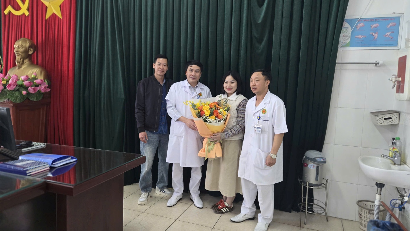 A group of people standing together holding flowers

Description automatically generated