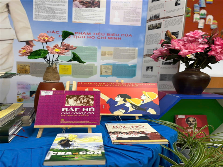 A table with books and flowersDescription automatically generated