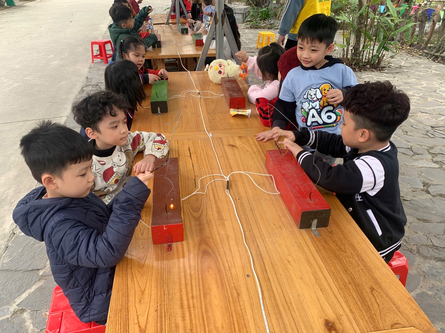 A group of children sitting at a table
AI-generated content may be incorrect.