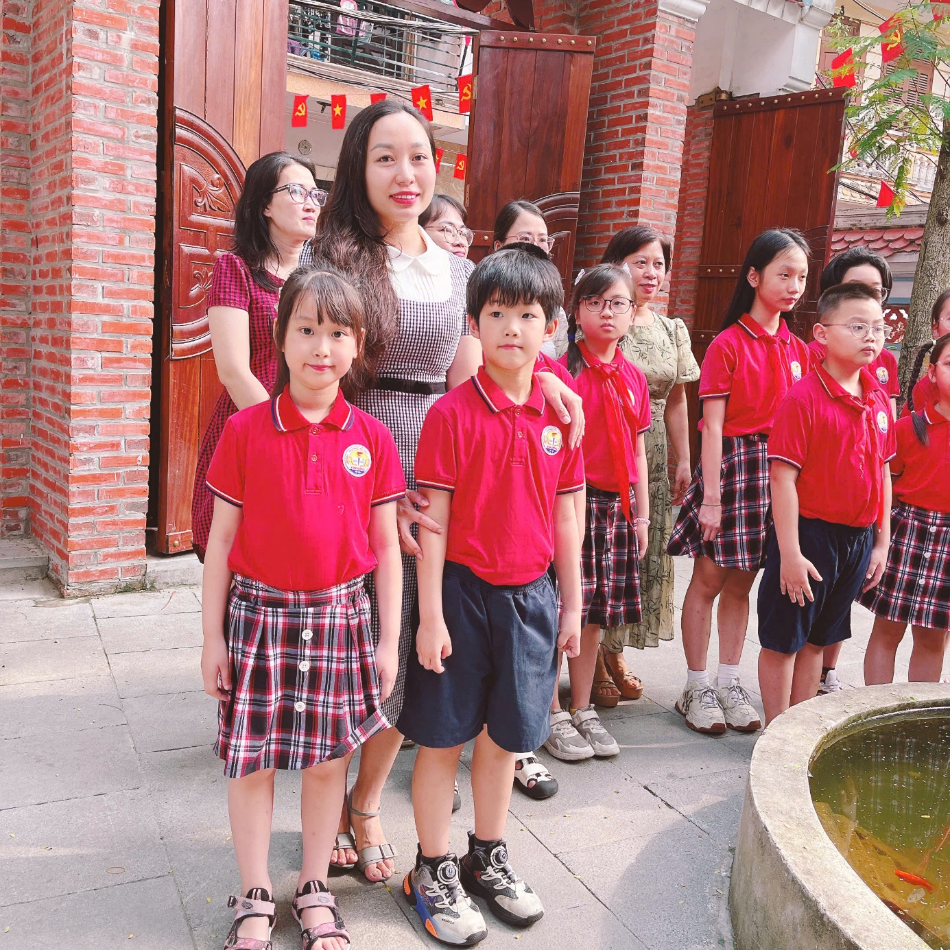 A group of people standing in front of a building
Description automatically generated
