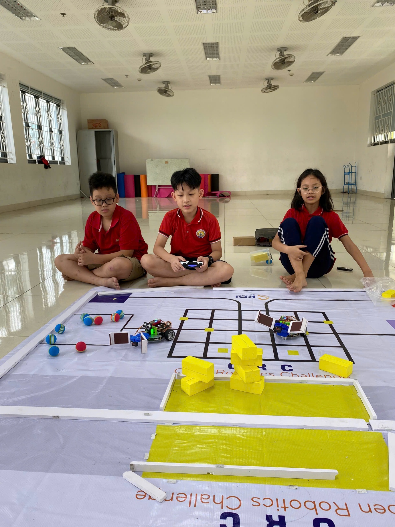 A group of kids sitting on a floor playing a game
AI-generated content may be incorrect.