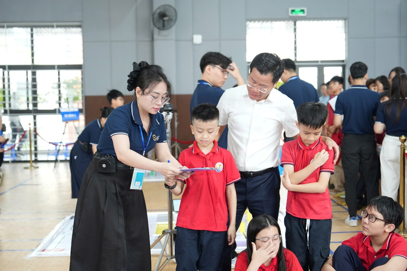 A group of people standing in a roomAI-generated content may be incorrect.