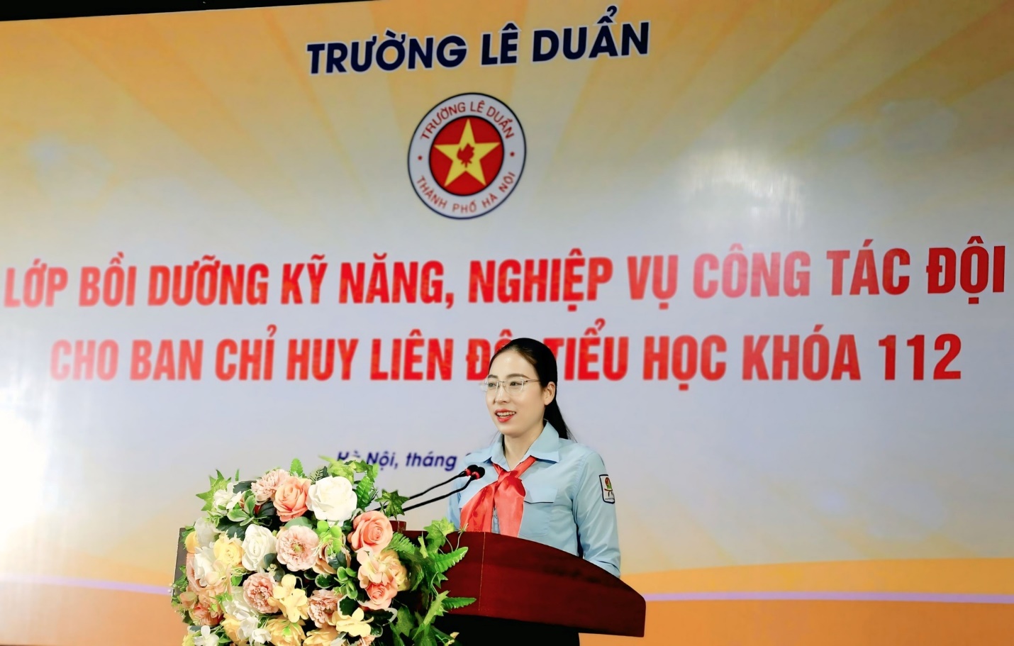 A person standing at a podium with a microphone and flowers
AI-generated content may be incorrect.