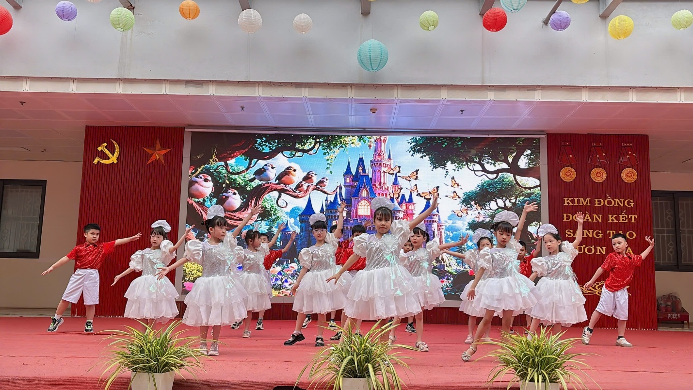 A group of girls in white dresses on a stage

Description automatically generated