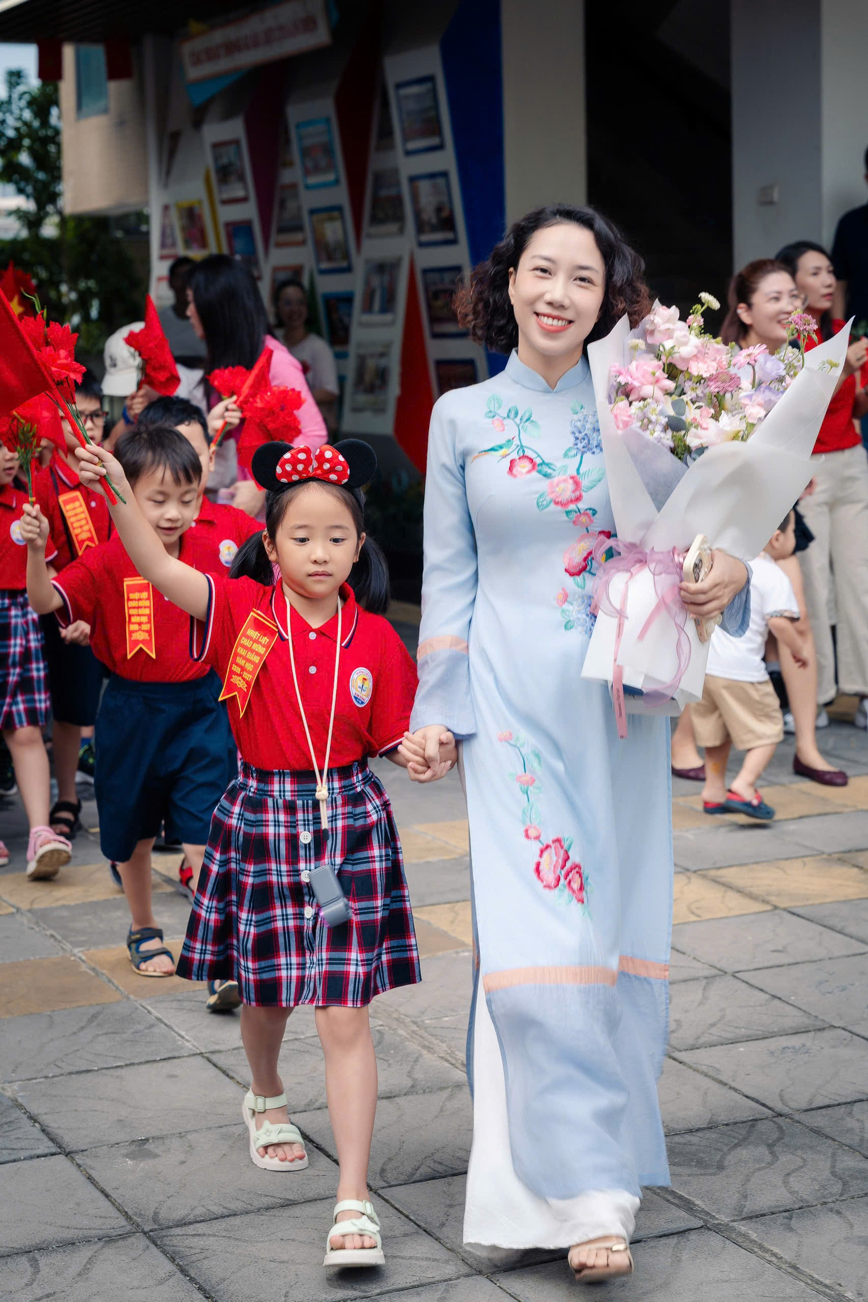 A person and child holding flowers

Description automatically generated