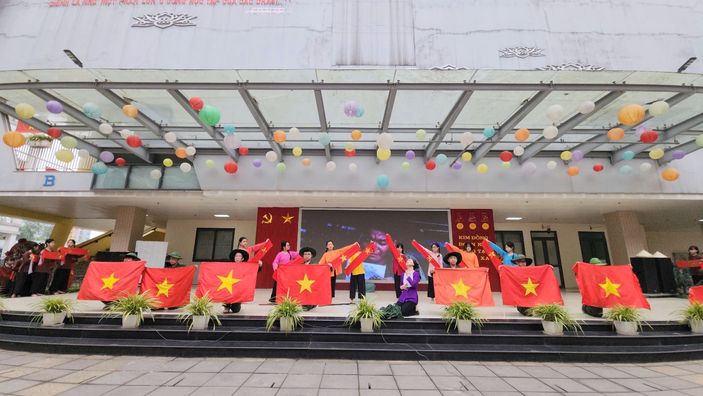 A group of people holding flags outside a building

Description automatically generated