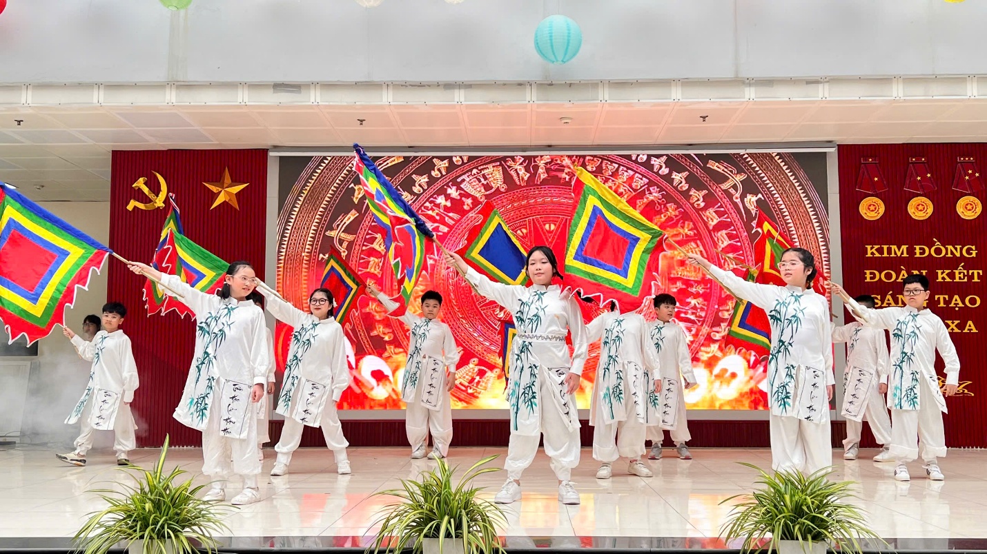 A group of people in white outfits on a stage

Description automatically generated